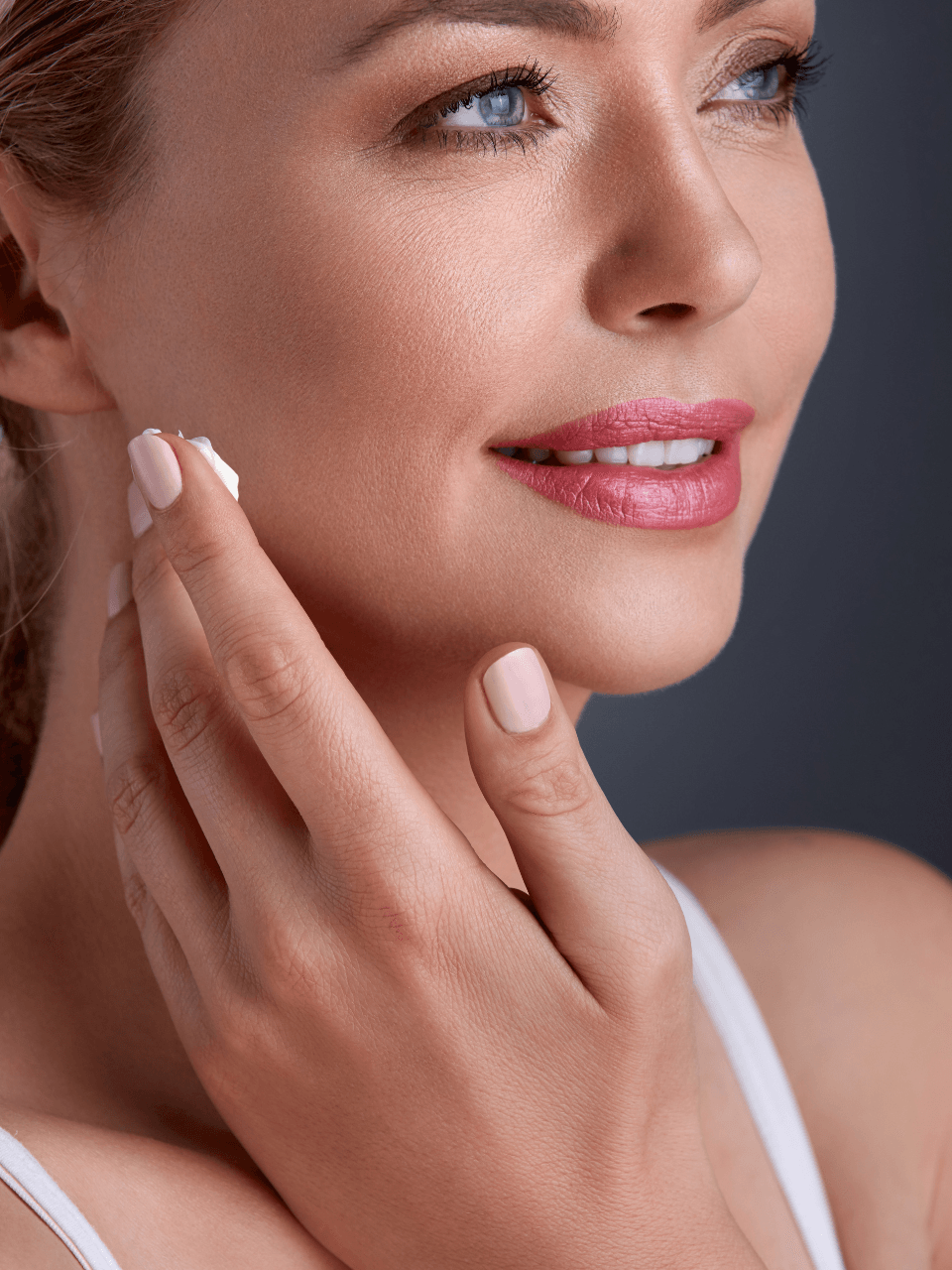 Woman applying Eclat Soin Anti-Age Day Cream with Hyaluronic Acid on her face for youthful skin